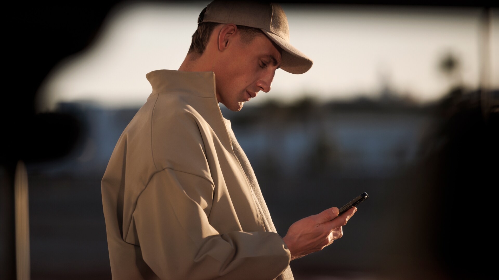 Uomo con uno smartphone e PEUGEOT E-5008